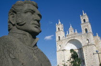Angled view of the Church of San Cristobal facade with head of statue of Don Ignacio de Allende in the foreground.