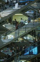 People on escalators inside the MBK Ma Boon Krong Shopping Center
