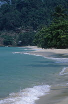 Chalets on a hillside at the northern end of Aow Bai Lan Lonely Beach with surf rolling onto the beach