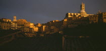 View across the city rooftops towards the Duomo and Campanile in late evening light.
