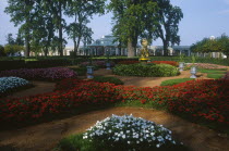 Peterhof Palace grounds.  View over formal gardens and borders with red and white flowers.