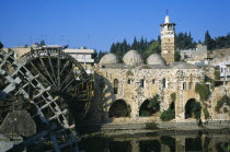 Wooden norias or waterwheels on the Orontes river and the Al Nuri Mosque dating from 1172 and built of limestone and basalt. Section of wheel in the immediate foreground.