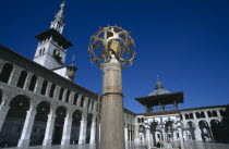 The Umayyad Mosque.  Lantern holder with ablutions fountain  Minaret of the Bride and arcade in the background.