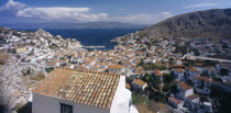 View over tiled rooftops of Hydra Town to harbour and distant coastline.