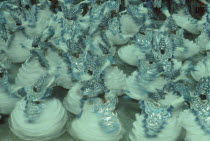 Carnival procession crowd in blue and white costumes spinning around