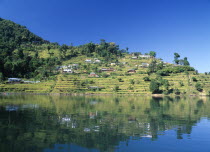 View over Lake Phewa with reflected terrace hillside and trees.