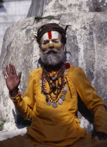 Hindu sadhu  follower of Shiva wearing saffron coloured  clothing and with painted face.