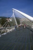 Bilbao.  The Zubuzuri footbridge with people crossing.