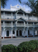Stone Town. The Old Dispensary  four storey building with decorative balconies  built in the 1890s.  Exterior view with palms in the foreground.