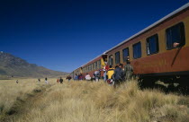 Train stopped on the altiplano at the highest pass on the line between Puno to Cusco.  People disembarking.