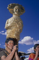 Young men carrying a golden Inca statue at Inti Raymi.