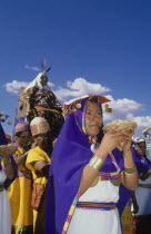 The wife of the Emperor Pachacuti being carried in her throne at Inti Raymi.   Women with offerings of food in the foreground.