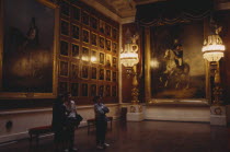 The Hermitage Museum interior  room hung with portaits  three people look at paintings