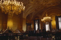 The Hermitage Museum interior  gilted room with display cabinets & visitors