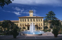 Elegant yellow town hall building with trees and a fountain in the foreground European Italia Italian Southern Europe