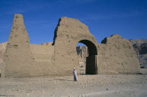 Temple of Hatshepsut entrance gateway with guide and Temple seen through archway