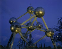 The Atomium illuminated at night with lights reflected on the base of the metal spheres