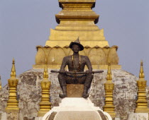 Pha That Luang Sacred Stupa with statue of King Setthathirat in foreground.