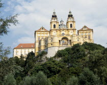 Melk Abbey with twin clocktowers on a hilltop surrounded by trees