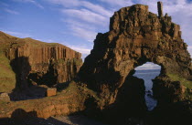 View through Carsaig arches formed from basalt rock and coastline