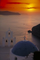 View across the water at sunset from above the blue and white church domes and bell tower
