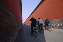 Imperial Palace with cyclists riding down a long red alleyway