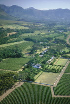 Boschendal Estate Wine Estate.  Aerial view over vineyards and winery with mountains in the background.