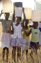 Hopewell  young girls carrying water on their heads from the Umgeni Water community water tap.