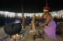 Shakaland  Zulu woman making beer shaking sorgum from a sieve.
