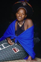Zulu woman in bright clothing sitting on the ground