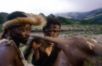 Zulu man teaching young boy how to throw a spear.