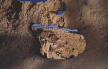 View through natural arch toward valley of colourful rock pinnacles