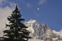 Haute Savoie. Snow covered Alps with Moon visible in the sky