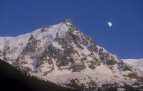 Haute Savoie. Snow covered Alps with the Moon in the sky