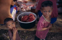 Karen refugees in Mae Lui village. Two children standing by bucket of raw bloodied meat