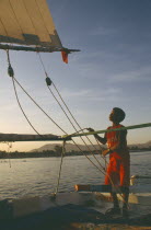 Felucca on the River Nile in the evening with young boy adjusting riggingChild labour