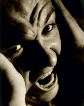 Man screaming and holding his head