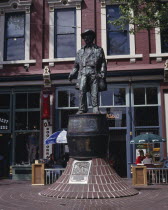 Gastown. Bronze statue of Gassy Jack the father of Gastown with a cafe behind