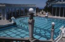 Greek Pool with columned surround and people gathered in the shade underneath