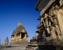 Vishvanath Temple and carved figures on stone base against blue sky