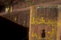 Bet Giorigos excavated Church of of St George with pilgrims standing on rim looking over the below ground church