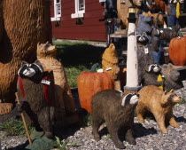 Display of coloured wood carvings of various bears with pumpkins