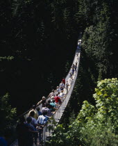 Capilano Suspension Bridge with tourists crossing the tree lined gorge