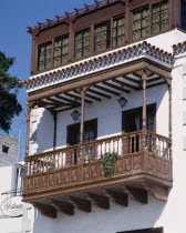 Traditional ornate wooden balcony on whitewashed house