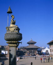 Main square with temple and gold statue on tall plinth.