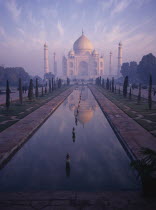 The Taj Mahal in pink misty light with the pool in the foreground