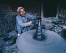 Local potter shaping vase on wheel