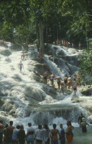 Dunns River Falls with tourists walking up through the pools holding hands