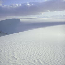 White sand dunes with clouds above