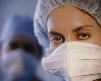 Portrait of female member of surgical team wearing mask and cap